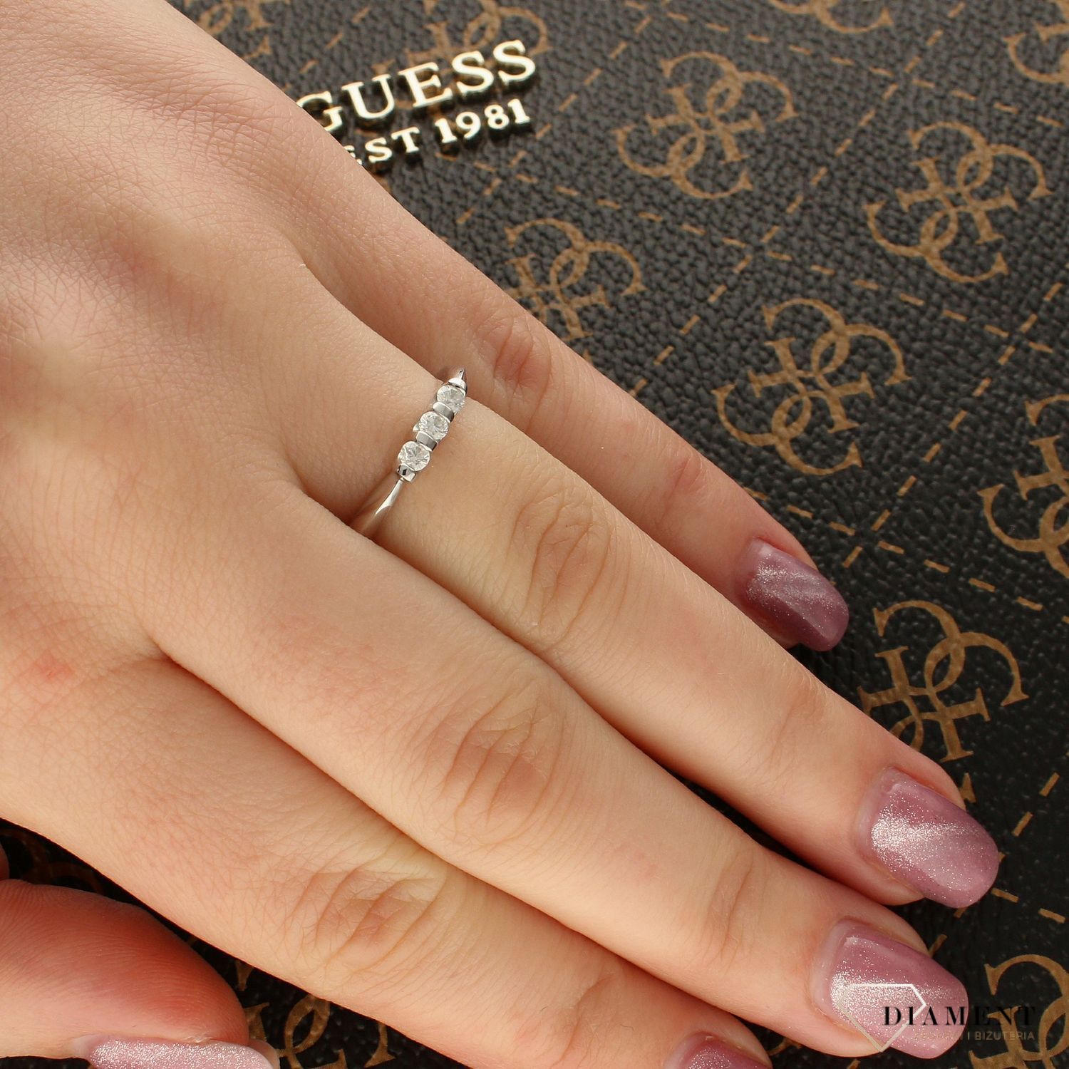 Elegancki pierścionek z białego złota próby 585, ozdobiony trzema brylantami o łącznej masie 0,20 ct, czystości P i barwie H. Idealny na prezent i wyjątkowe okazje.1.jpg